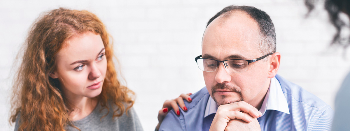  Supportive wife comforting husband with TRD during a meeting with a counselor in Toms River.